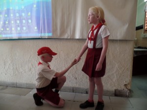 Ein Blindenschüler in Uniform knieht vor einer Mitschülerin. Hält er um ihre Hand an?