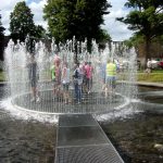 Tandemfahrer umringt von Wasser in einem begehbaren Brunnen