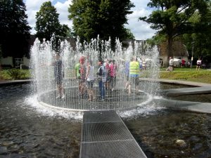 Tandemfahrer umringt von Wasser in einem begehbaren Brunnen